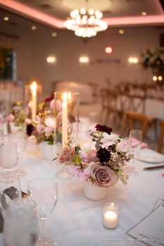 the table is set with flowers and candles