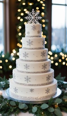 a white wedding cake with snowflakes on it