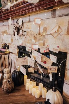 the fireplace is decorated with many cards and candles for halloween time, as well as other decorations