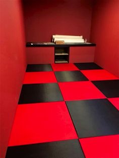 a red and black checkered floor in a room with a shelf on the wall