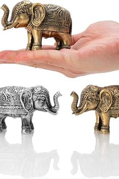 three small elephant figurines sitting in the palm of someone's hand,