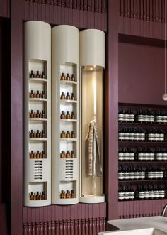 a room with many bottles on the wall and shelves full of essential oils in them