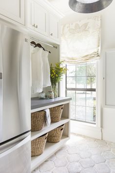 a kitchen with white cabinets and baskets on the counter