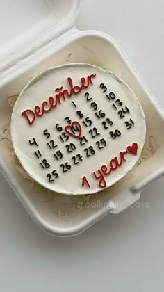 a decorated cake in a plastic container with writing on it