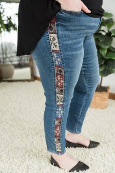 a woman standing on top of a white carpet wearing jeans and black shoes, with her hands in her pockets