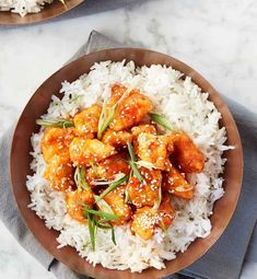 two brown plates filled with rice and chicken