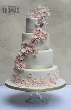 a three tiered wedding cake with pink flowers on it