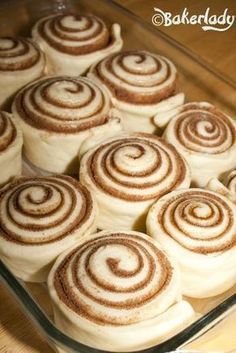 cinnamon rolls in a glass baking dish on a wooden table