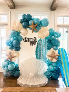 the balloon arch is decorated with starfishs, seashells and other decorations