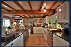 the kitchen is clean and ready for us to use it's counters are white with black counter tops