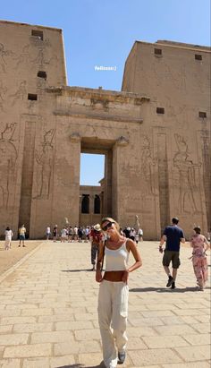 a woman standing in front of an egyptian temple