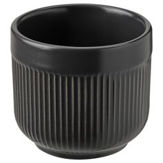 a black cup is sitting on a white surface and it has pleated lines in the bottom