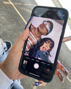 a person holding up a cell phone to take a selfie with the image on it