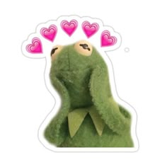 a green stuffed animal with pink hearts on it's head and eyes, sitting in front of a white background