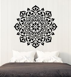 a black and white wall decal with an intricate design on the side of a bed