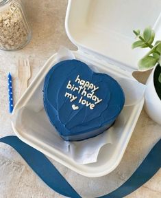 a blue heart shaped cake sitting on top of a white plate next to a fork