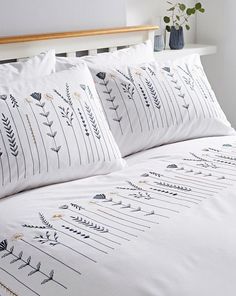 a white bed topped with lots of pillows