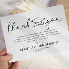 someone holding up a thank card with the words, thank you on it in black ink