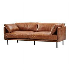 a brown leather couch sitting on top of a white wall