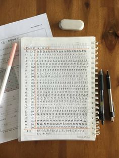 an open notebook with chinese writing on it next to a pen and some other items