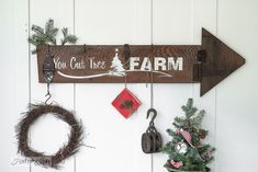 a wooden sign that says you can't miss farm hanging on a wall next to two christmas wreaths