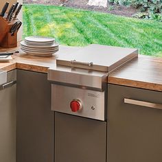 a stainless steel dishwasher sitting on top of a counter next to a window