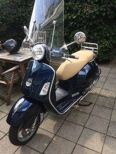 a blue scooter parked next to a wooden table