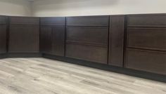 an empty kitchen with dark wood cabinets and white walls