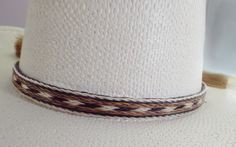 Cowboy hat band, genuine horsehair hat band, Five Strands wide ( 5/8 inch) BOLDLY done in a a natural brown-rich black and off-white Double horse hair tassels, Oh So Stetson perfect, **VERY Distinctive look **OUTSTANDING QUALITY ** STETSON perfect ** LUXURIOUS 100% genuine horsehair ** 5/8 inch wide. You will quickly discover that nothing compares to this extraordinary beauty: This horsehair hat band DEMANDS attention. This beauty is a 5 strands wide. Each strand is about 1/8 inch wide, separate Classic White Hat Bands For Rodeo, Classic White Hat Band For Rodeo, White Fedora Panama Hat For Ranch, White Short Brim Panama Hat For Ranch, Classic White Panama Hat For Ranch, White Western Panama Hat For Western-themed Events, White Adjustable Classic Hat Bands, Adjustable White Fedora Hat Bands, Elegant Brown Hat Band For Ranch