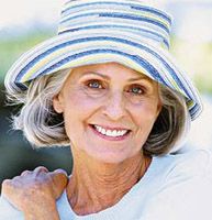 an older woman wearing a blue and white striped hat with her hand on her shoulder