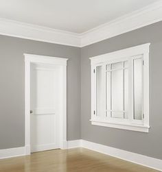 an empty room with gray walls and white trim on the doors, hardwood flooring