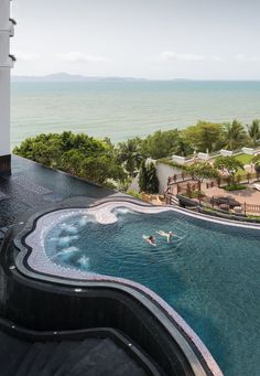 an outdoor swimming pool next to the ocean