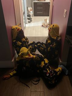 two people in yellow and black pajamas sitting on the floor