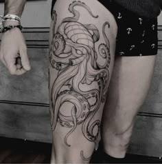 an octopus tattoo on the leg of a man's lower body, with black and white ink