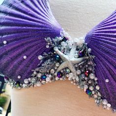 a woman's bra with purple and white beads on it