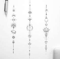 an assortment of tattoos on a white wall next to a pen and paper with ink