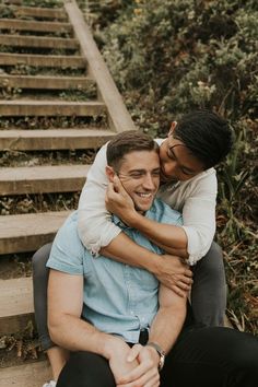 a man and woman hugging each other on the steps