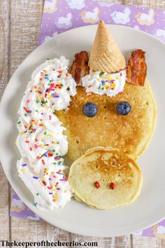 a plate with pancakes, bacon, and ice cream on it that has been made to look like a face