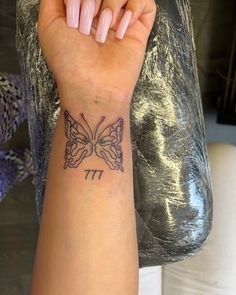 a woman's arm with a butterfly tattoo on the left side of her wrist