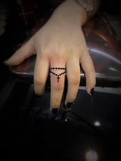 a woman's hand with a cross tattoo on it