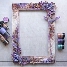 an old frame with some crafting supplies on it next to thread and glue bottles