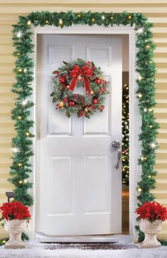 a white door decorated with christmas wreath and poinsettis