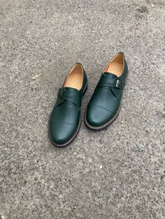 "Elevate your footwear game with our dark green monk strap shoes for women. These shoes feature a classic monk strap design, a soft natural leather upper, and a durable rubber sole for all-day comfort. Handcrafted with care, each pair is made from the finest materials to ensure both style and durability. The rich, dark green color of these monk strap shoes adds a unique touch to any outfit. The soft natural leather upper not only looks great but also ages beautifully over time, developing a unique patina that adds character and charm. Whether you're dressing up for a night out or running errands, these shoes are sure to make a statement. Don't settle for ordinary shoes when you can have the best. Add a pair of our dark green monk strap shoes to your collection today and step out in style a Green Business Loafers With Leather Sole, Green Leather Shoes With Brogue Detailing For Business, Green Slip-on Oxfords For Business, Green Leather Shoes With Leather Sole For Business, Green Leather Business Shoes With Leather Sole, Workwear Monk Strap Slip-on Shoes With Rubber Sole, Green Wingtip Dress Shoes With Brogue Detailing, Classic Green Loafers For Business, Green Leather Sole Slip-on Loafers