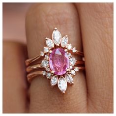 a close up of a person's hand with a pink ring on their finger