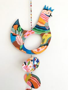 a colorful bird decoration hanging from a wall