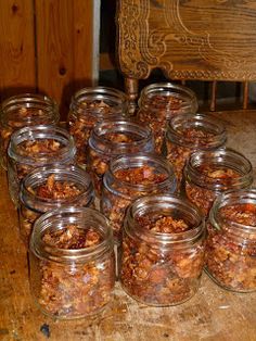 many jars filled with food sitting on top of a wooden table