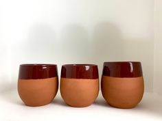 three red and brown cups sitting next to each other