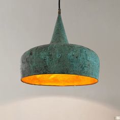 a green pendant light hanging from a ceiling