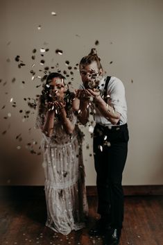 two people standing next to each other with confetti in their hands