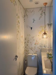 a bathroom with floral wallpaper and white toilet